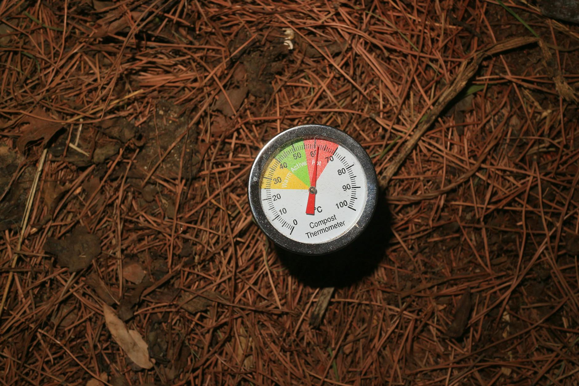 Person turning a backyard compost pile with a garden fork