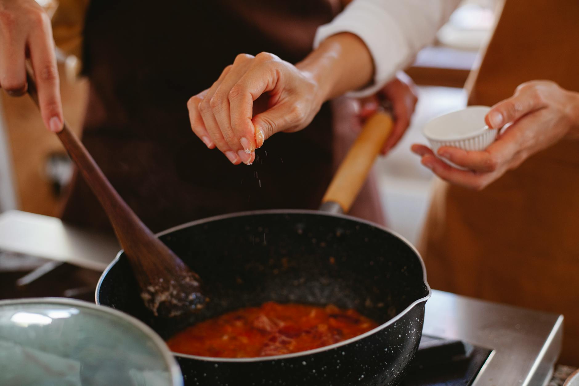 Whisking homemade brown gravy in a saucepan on the stove