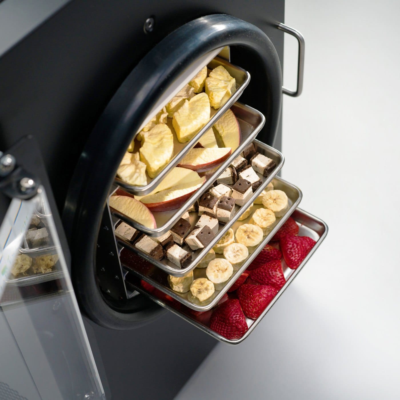 A Harvest Right home freeze dryer open with its stainless trays loaded